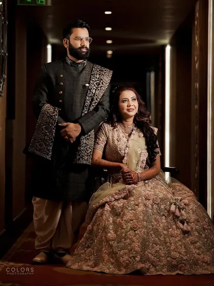 A formal, elegant portrait of the couple in a beautifully lit hallway at their reception venue.