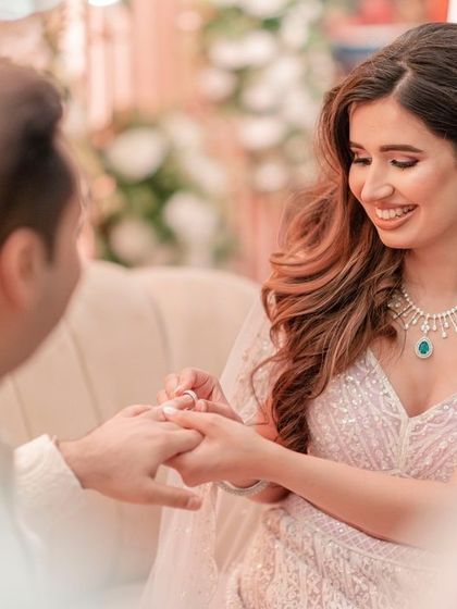 The bride smiles as she places the ring on her groom's finger, captured from a beautiful, intimate angle.