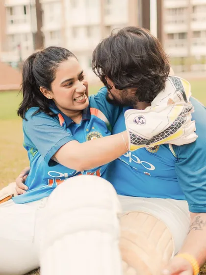 A joyful, candid embrace on the field. This image is all about the genuine smiles and easy-going love this couple shares, perfectly captured during their unique cricket photoshoot.