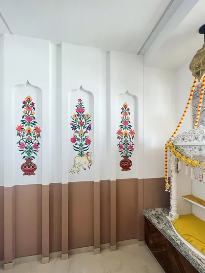 For this pooja room, I painted traditional Kalamkari art within the wall niches. The floral patterns and the sacred cow add a classic, divine touch to the mandir space.