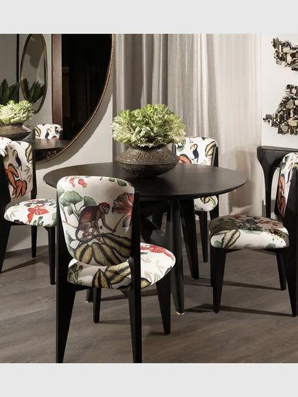 The Toco Toucan Dining Chair, crafted from solid teak wood and upholstered in a vibrant, tropical-printed fabric. This piece adds a touch of playful elegance and personality to a dining setting.