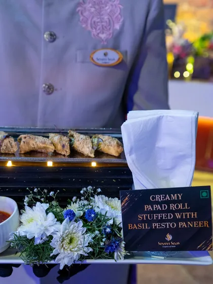 Creamy Papad Rolls stuffed with Basil Pesto Paneer. This fusion appetizer combines Indian textures with Italian flavours, served on an elegant floral tray.