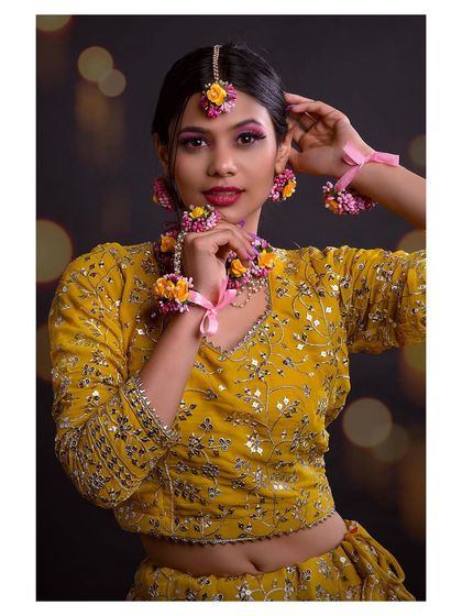 A close-up portrait that captures the model's happy expression and the vibrant colors of her makeup and jewelry.