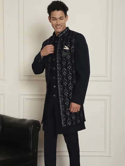 A full view of the navy blue kurta and long jacket set. The contrast between the plain kurta and the heavily embroidered jacket creates a powerful style statement.