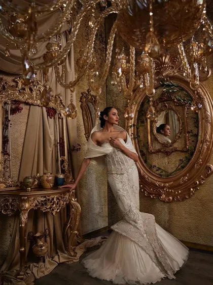 In this ivory gown, I explored the contrast between a corseted, fit-and-flare silhouette and the soft power of a dramatic hooded panel. The hand embellishments are meticulously placed to catch the light, creating a piece that feels both intentional and unforgettable, perfect for a modern bride.