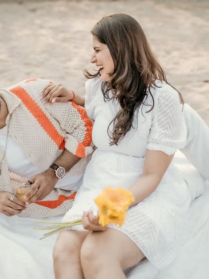 Pure joy and laughter captured during a casual beach picnic. This candid shot shows the fun and playful side of the couple's relationship.