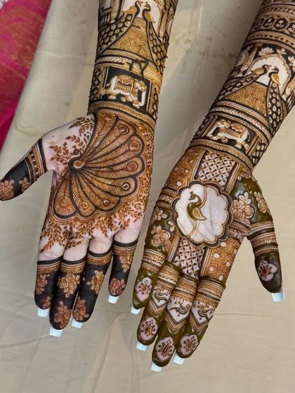 A close-up of the palms, showing the beautiful peacock feather and floral designs, with intricate patterns on the fingers.