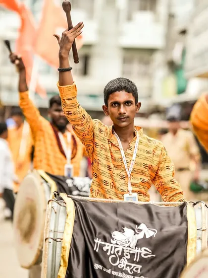 The color version of the young dhol player, his orange shirt bright and festive.