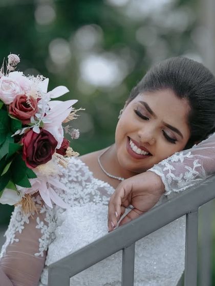 A moment of quiet reflection for the bride. Her eyes are closed as she holds her bouquet, creating a serene and thoughtful bridal portrait.