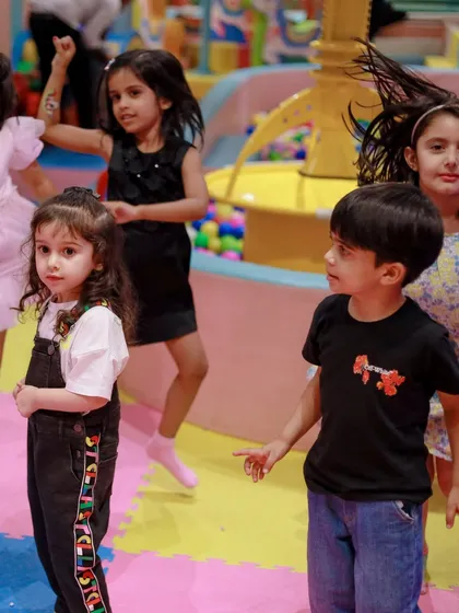 The kids are all dancing and playing together, fully immersed in the fun of a themed birthday party.