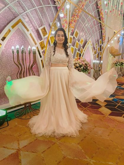 A client looking ethereal in a white lehenga with dramatic bell sleeves, perfect for making a statement.