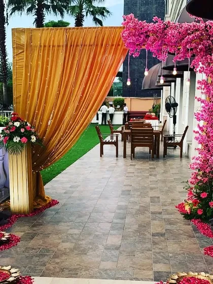 We make sure your guests are impressed from the moment they arrive. This beautiful event entrance features a dramatic orange drape, a stunning pink cherry blossom tree, and floating lotus bowls with flower petals.
