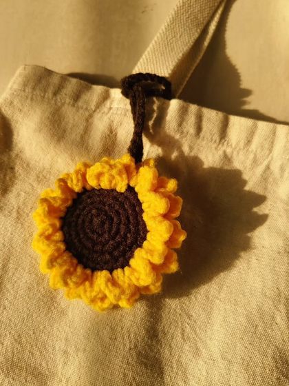 Add a little sunshine to your tote with this crochet sunflower bag charm. It's a beautiful, handmade accessory that brings a cheerful vibe to any bag.