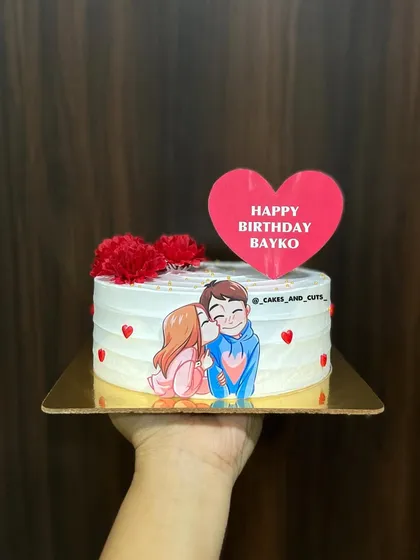 A personalized cake for "Bayko" (wife) with a cute couple illustration and fresh flowers.