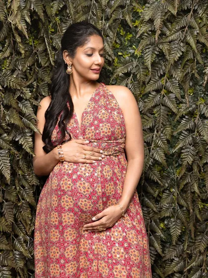 A quiet moment of reflection against a lush green backdrop. This traditional maternity shoot beautifully blends culture with nature.
