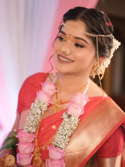 A beautiful portrait of the bride during her wedding ceremony, adorned with a floral garland. Her makeup is fresh and radiant, perfect for the occasion.