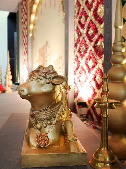 A beautifully crafted Nandi statue, adorned with traditional jewelry, stands guard at the entrance. This brass-finished sculpture was a key element in establishing the authentic temple ambiance from the moment guests arrived.