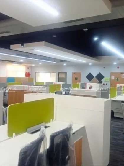 A closer look at the workstation setup in a modern open-plan office. The cubicles feature lime green and grey privacy screens, adding a touch of color while maintaining a professional look. This design balances collaboration with individual focus areas.