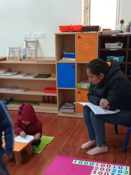 A trainee observes a child working independently. A key skill we teach is the art of observation. Learning to watch without interrupting allows the teacher to understand the child's needs and know exactly when and how to offer guidance.