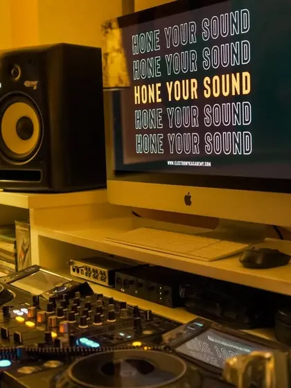 A close-up of the workstation where you'll spend your time learning. The setup includes an iMac for running production software, professional monitors, and a DJ controller, providing everything you need to start creating.