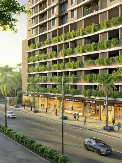 A street-level view of the North Mumbai residential project, showing the integration of retail spaces at the podium level with lush green planters.