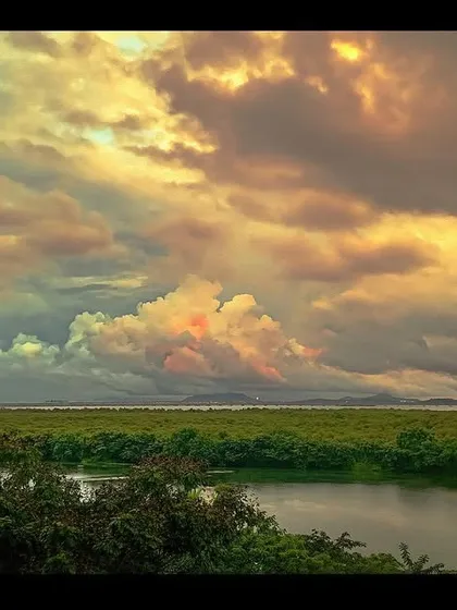 A dramatic sunset over the wetlands and mangroves of Navi Mumbai, shot on a phone. The powerful colors and cloud formations show that moments of profound beauty are everywhere, waiting to be captured.