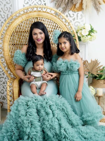 A mother and her two children, a portrait of grace. The older sister's poise and the baby's calm demeanor make this a truly special photograph.