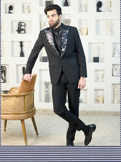 A framed, full-length shot of the black tuxedo with a patterned lapel, presenting it as a sophisticated ensemble for any formal occasion.