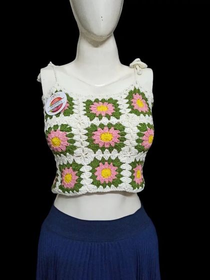 A bright and summery crop top made with daisy granny squares. The combination of white, pink, and green is so fresh. The tie-up straps make it easy to adjust for comfort.