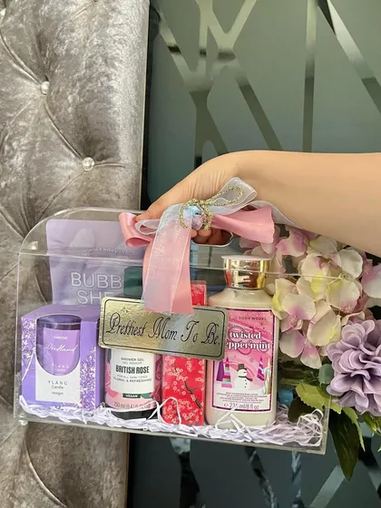 Our luxe acrylic bag hampers are so chic and totally customizable. This one was designed for a special mom-to-be, filled with pampering essentials like lotions, a scented candle, and a bubble sheet mask, all in a pretty purple theme with a custom "Prettiest Mom To Be" tag.