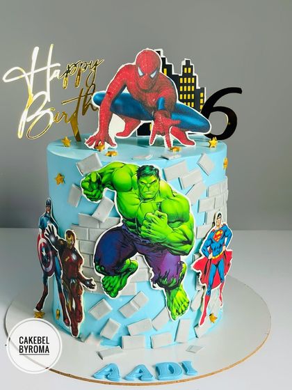 An action-packed Avengers cake where Hulk smashes through a brick wall. This design features multiple heroes like Spider-Man, Iron Man, and Superman ready for battle.