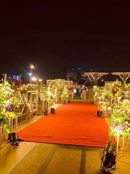 For formal corporate events, the entrance sets a tone of prestige. I designed this classic red carpet arrival for a congratulatory ceremony, lined with modern geometric light fixtures and lush floral arrangements to honor the guest of the evening.