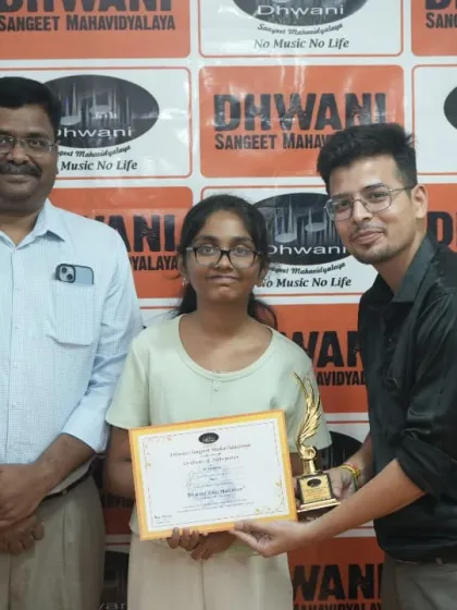 A teacher and our director present an award to a student.