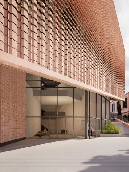 A close-up of the terracotta facade and the entrance to the MAXXI building, demonstrating the texture and warmth of the materials chosen for the project.
