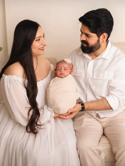 New parents holding their precious baby together. I love capturing the look of awe and love on their faces.