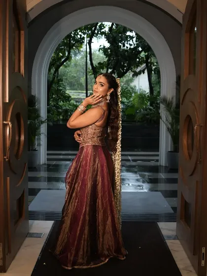 A complete look at this stunning bridal Mehendi style. The rich, multi-toned lehenga was paired with a glamorous makeup look featuring a shimmery eye, glowing skin, and a beautiful long ponytail adorned with mogra flowers.
