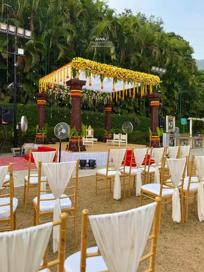 A view of the mandap from the guest seating area, showing the beautifully draped chairs and the clear view of the ceremony space.