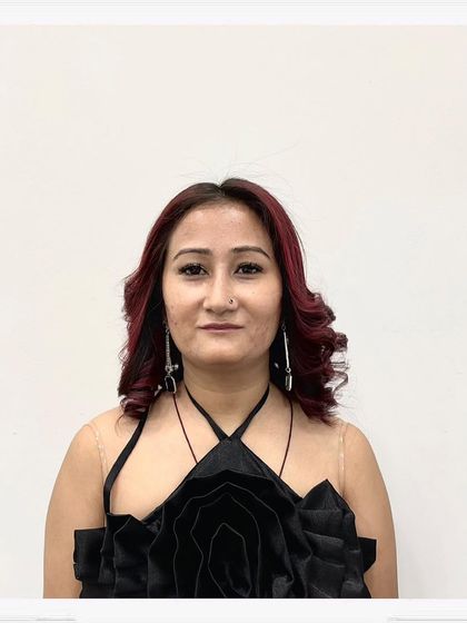 A portrait of the client enjoying her new red hair and curly style. She looks confident and ready for any occasion.