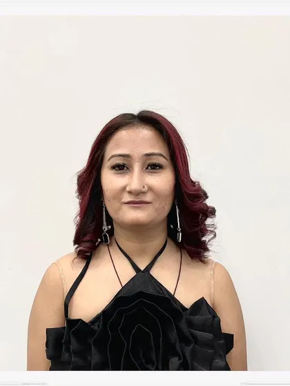 A portrait of the client enjoying her new red hair and curly style. She looks confident and ready for any occasion.