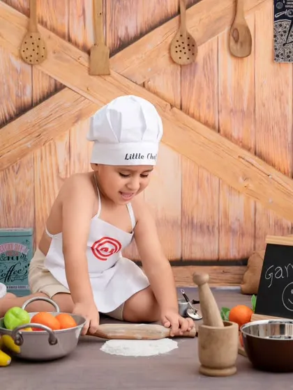 This little chef is focused on rolling out his dough, a candid moment captured during our popular kitchen-themed session.