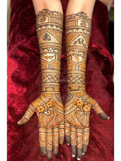 A unique bridal design with 3D-style floral elements on the palms. The arms feature traditional motifs like elephants and personalized initials, creating a modern yet classic look.