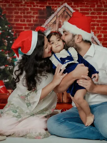 Christmas kisses for the little one! This photo is overflowing with love and holiday cheer, a perfect candid moment for this family.