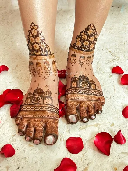 Bridal mehndi isn't just for hands. I love adorning feet with designs like this, featuring delicate architectural domes and floral patterns, beautifully framed with scattered rose petals for the perfect shot.