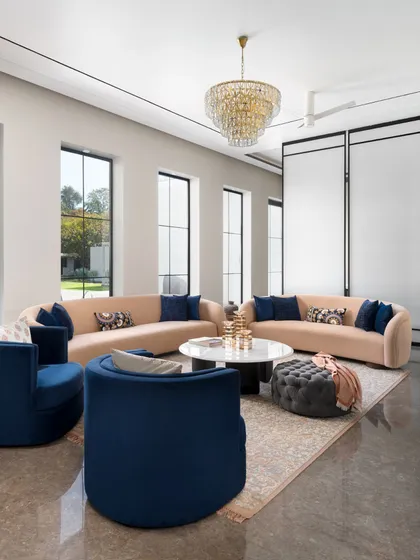 In this seating arrangement, we used deep royal blue chairs to create a striking contrast against the soft, neutral sofas. This demonstrates our approach to using color boldly yet elegantly to define different zones within an open-plan living space.