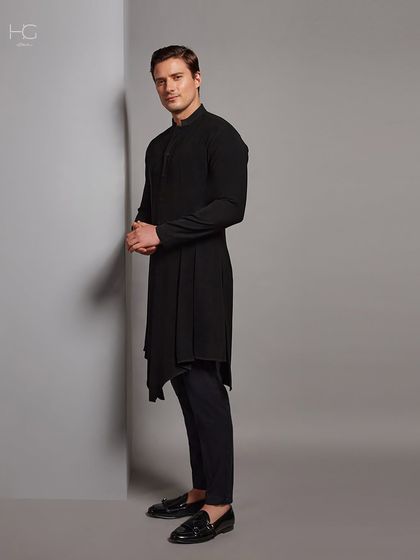 The side profile of the black asymmetrical kurta shows off its unique cut and how it creates a striking, memorable silhouette.