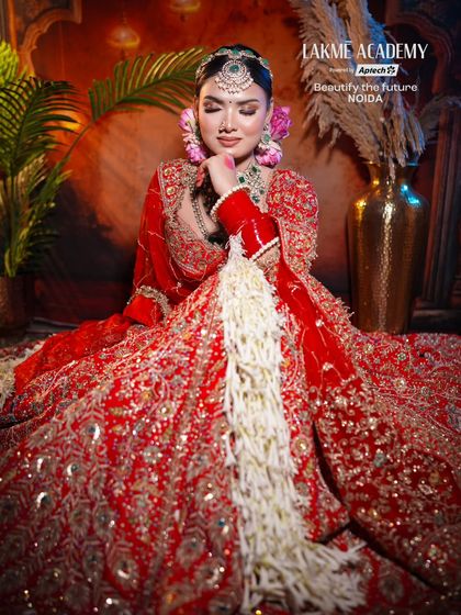 Creating a complete bridal look involves more than just makeup. Here, we focus on the entire presentation, from the floral hair accessories to the way the gajra complements the intricate red lehenga.