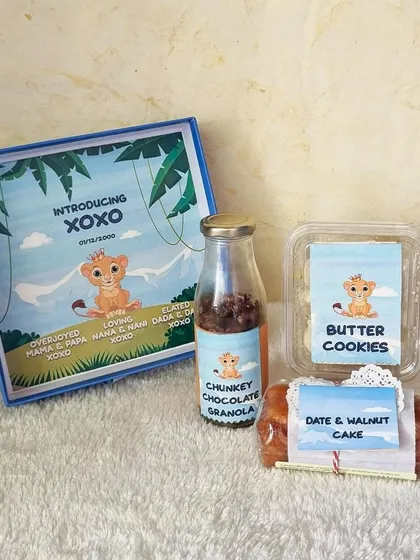 Announcing the Sweetest New Arrival. Welcome a new baby with our adorable, personalized announcement hampers. This custom box introduces the little one with a selection of our handmade treats like Butter Cookies and Date & Walnut Cake.