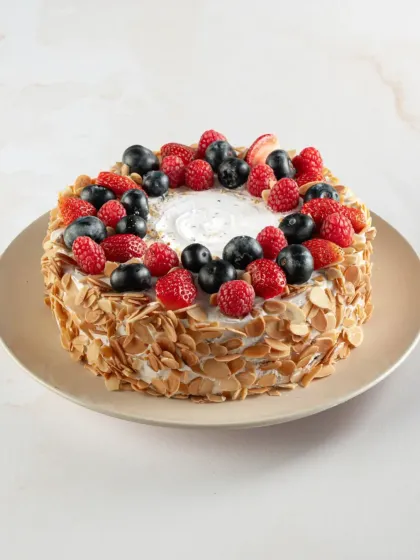 Our Mixed Berry Almond Gateau is a beautiful cake, with a crown of fresh berries and a coating of crunchy toasted almonds. It’s as delicious as it is pretty.