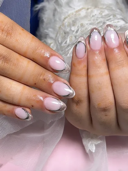 A clean and modern look with a milky pink base and a raised silver chrome French tip for a futuristic feel.
