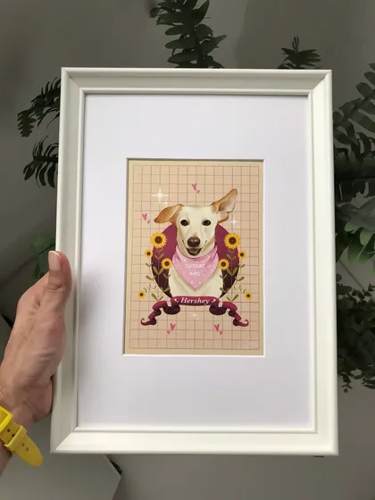 Holding the framed portrait of Hershey. The white frame provides a clean, classic look that complements the colorful and cheerful illustration.